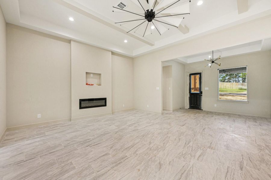View of the  Family  area features modern tile flooring, electric fireplace, and large windows for natural light.