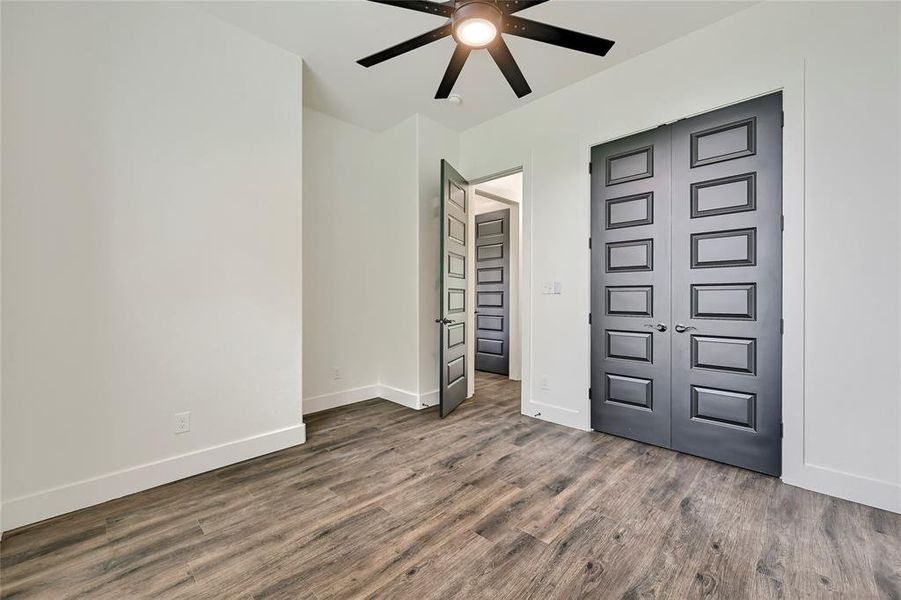 Unfurnished bedroom with baseboards, a ceiling fan, wood finished floors, and a closet