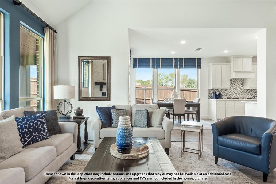 Open-concept living room with gray sofas, blue accents, and kitchen visible in background Open-concept living room with gray sofas, blue accents, and kitchen visible in background