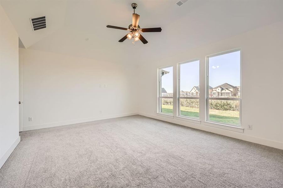 Empty room with carpet floors, ceiling fan, and lofted ceiling