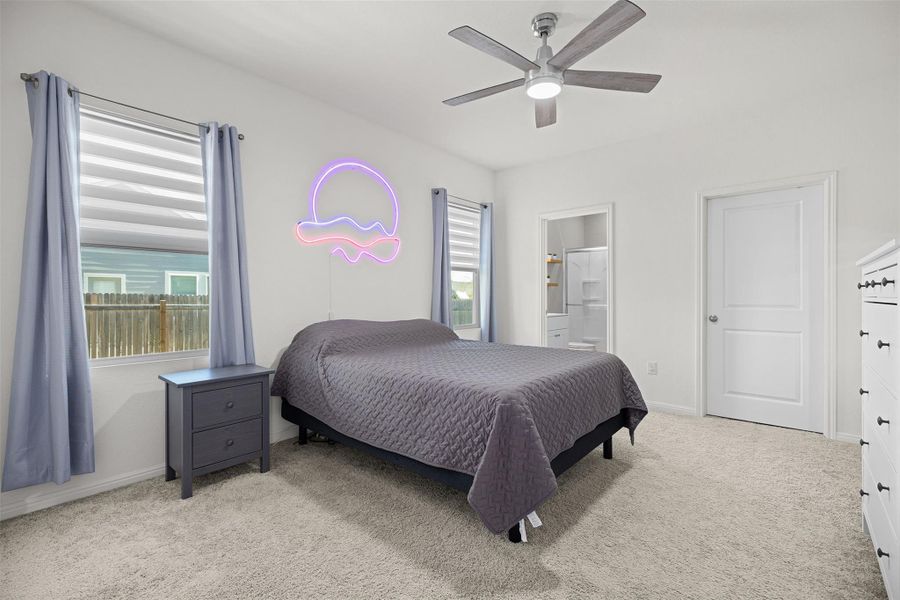Bedroom featuring carpet flooring, ceiling fan, and connected bathroom Bedroom featuring carpet flooring, ceiling fan, and connected bathroom