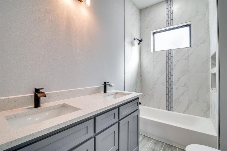 Bathroom with hardwood / wood-style floors, vanity, and tiled shower / bath combo