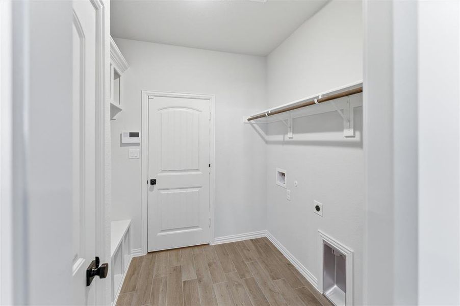 Laundry room with wood finish floors, hookup for an electric dryer, and washer hookup