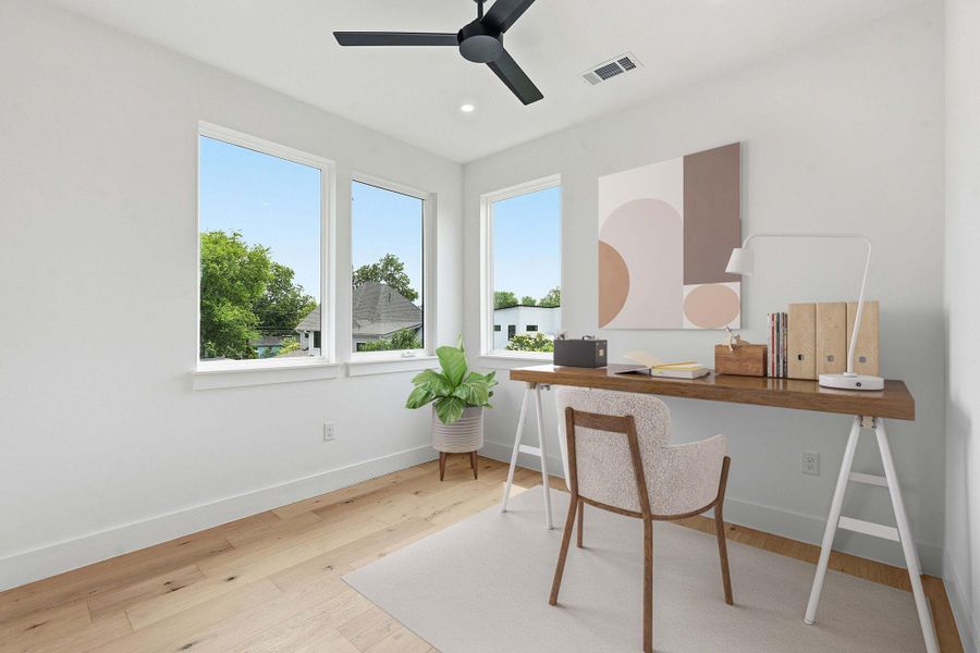 Bright room featuring three large windows, light wood-finish flooring, recessed lighting, a ceiling fan, and white baseboards