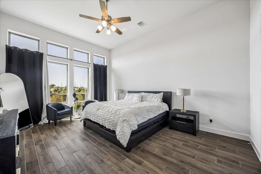 Spacious primary suite featuring soaring ceilings, expansive windows, and abundant natural light