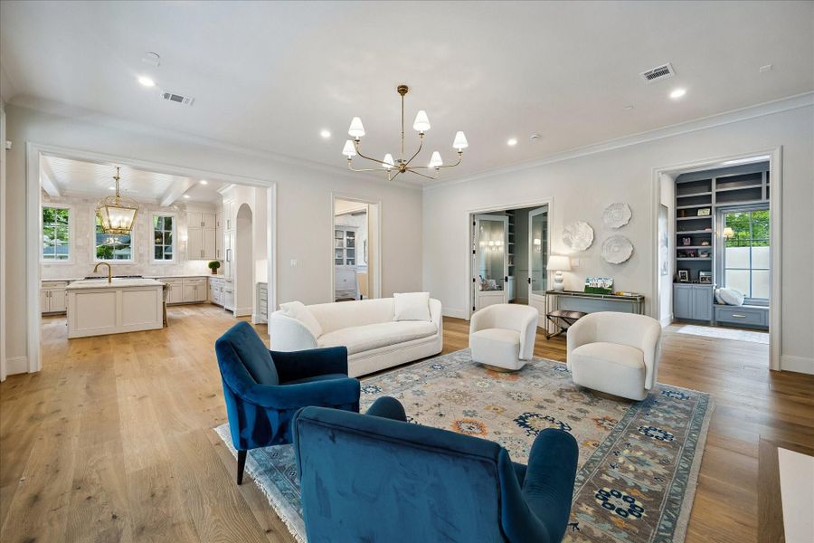 Looking back toward the kitchen, the expansive living area highlights its seamless connection to the heart of the home. Wide openings enhance the airy feel, while the elevated finishes and architectural detailing continue throughout, creating a cohesive and inviting living environment.
