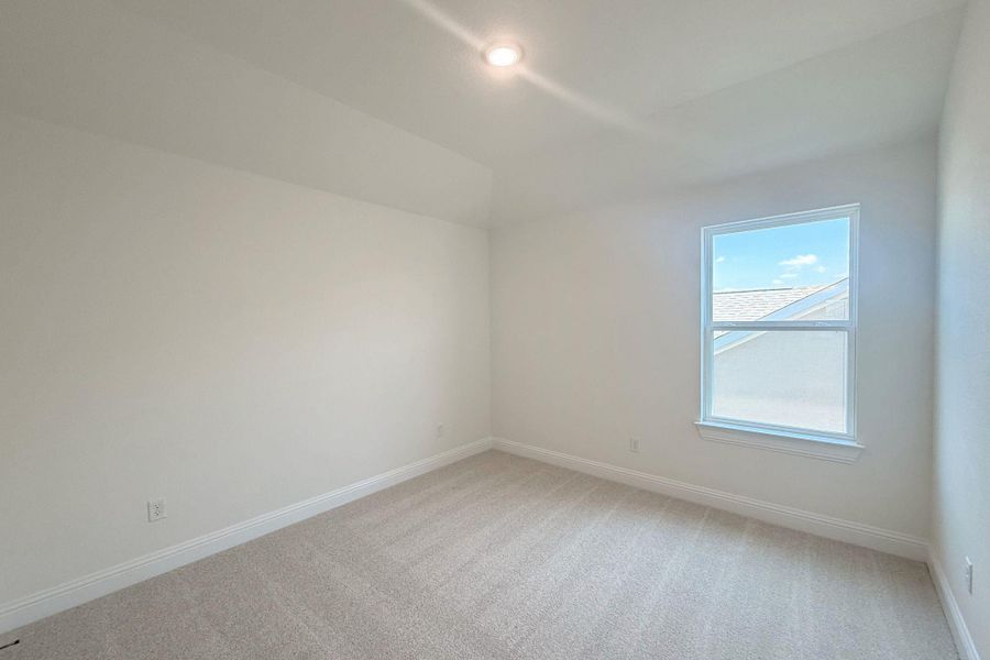Bright room featuring a single window, recessed lighting, neutral carpet, white baseboards, and a tray ceiling detail