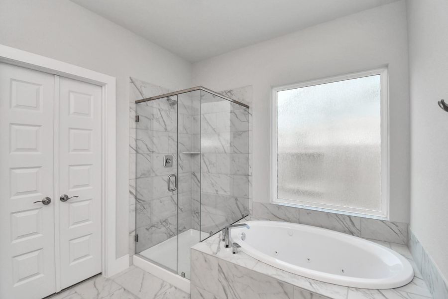 Indulge in a spa-like retreat within the confines of this primary bathroom. Delight in a spacious walk-in shower enveloped in stylish tile surround and unwind in a separate garden tub adorned with custom detailing. Sample photo of completed home with similar floor plan. Actual colors and selections may vary. Indulge in a spa-like retreat within the confines of this primary bathroom. Delight in a spacious walk-in shower enveloped in stylish tile surround and unwind in a separate garden tub adorned with custom detailing. Sample photo of completed home with similar floor plan. Actual colors and selections may vary.