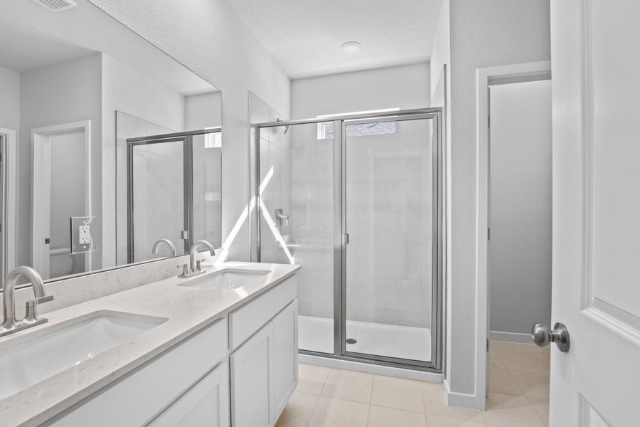 Lot 144 Primary Bath with Walk-In Shower and Dual Vanities at Camden Woods in Kingsland Lot 144 Primary Bath with Walk-In Shower and Dual Vanities at Camden Woods in Kingsland