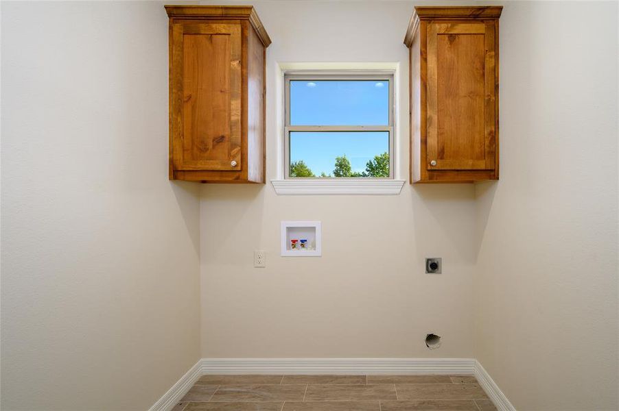 Laundry room featuring washer hookup, hookup for an electric dryer, and cabinets