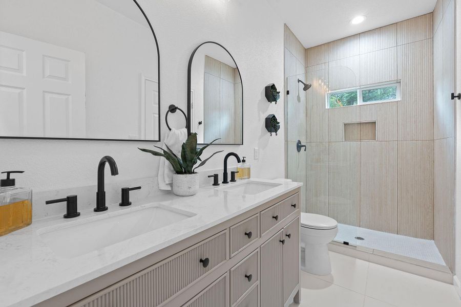 Full bath featuring a walk in shower, double vanity, tile patterned floors, and recessed lighting