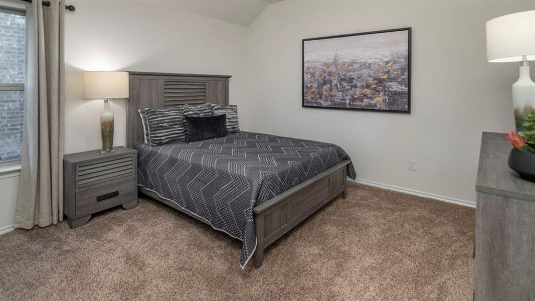Carpeted bedroom with baseboards and lofted ceiling