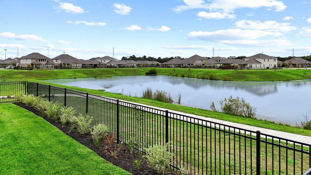 Enjoy breathtaking lakefront views right from your backyard, framed by wrought iron fencing and manicured landscaping—an ideal setting for peaceful mornings or evening sunsets. Enjoy breathtaking lakefront views right from your backyard, framed by wrought iron fencing and manicured landscaping—an ideal setting for peaceful mornings or evening sunsets.