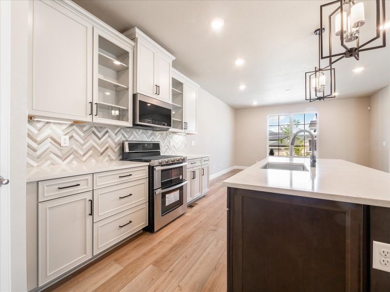 The designer decorated kitchen spills into the dining room allowing for an open feel.