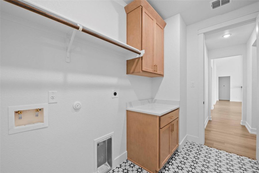 Laundry area featuring gas dryer hookup, hookup for an electric dryer, cabinet space, and washer hookup Laundry area featuring gas dryer hookup, hookup for an electric dryer, cabinet space, and washer hookup