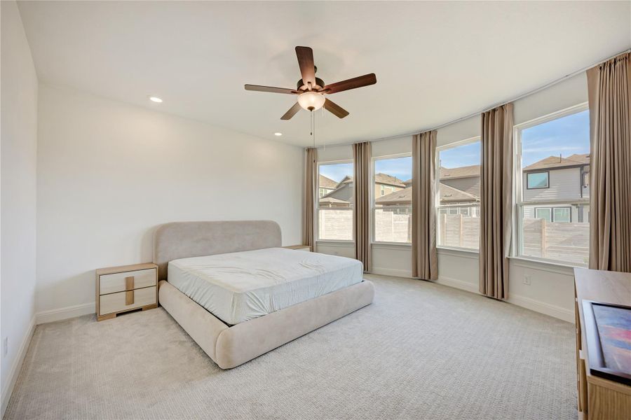 Spacious room featuring light-toned carpet, a ceiling fan with integrated lighting, and recessed ceiling lights