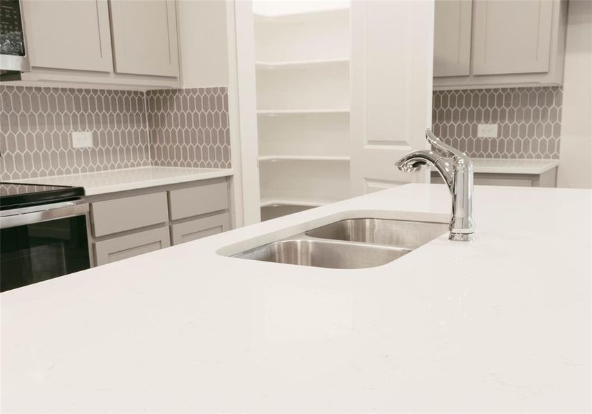 Kitchen featuring sink, electric stove, and tasteful backsplash