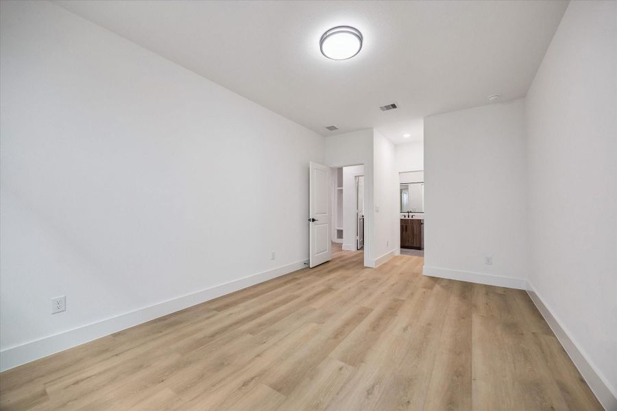 Light-filled bedroom with clean flooring and flexible furniture placement