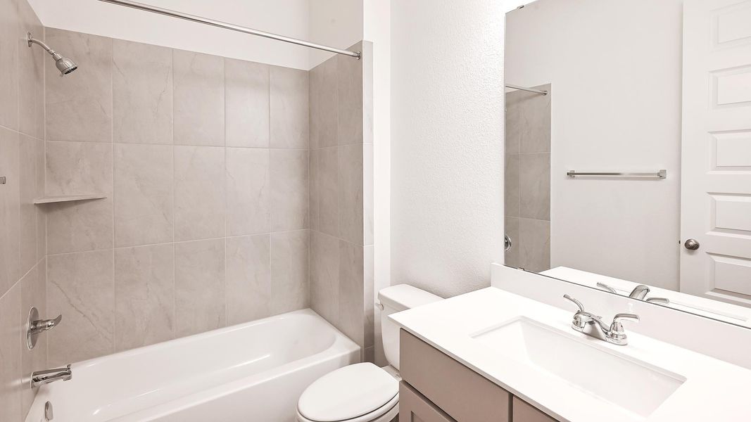 Bathroom featuring toilet, vanity, and shower / tub combination
