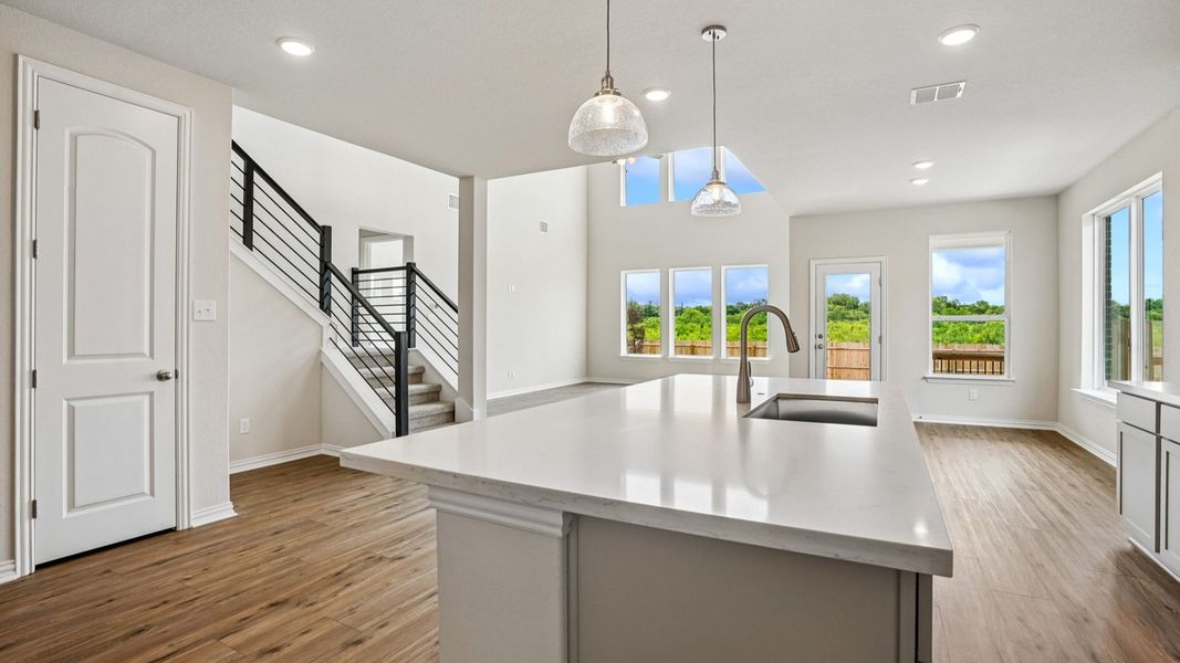 Modern Kitchen Features Built-in Appliances, Pendant Island, and Center Island