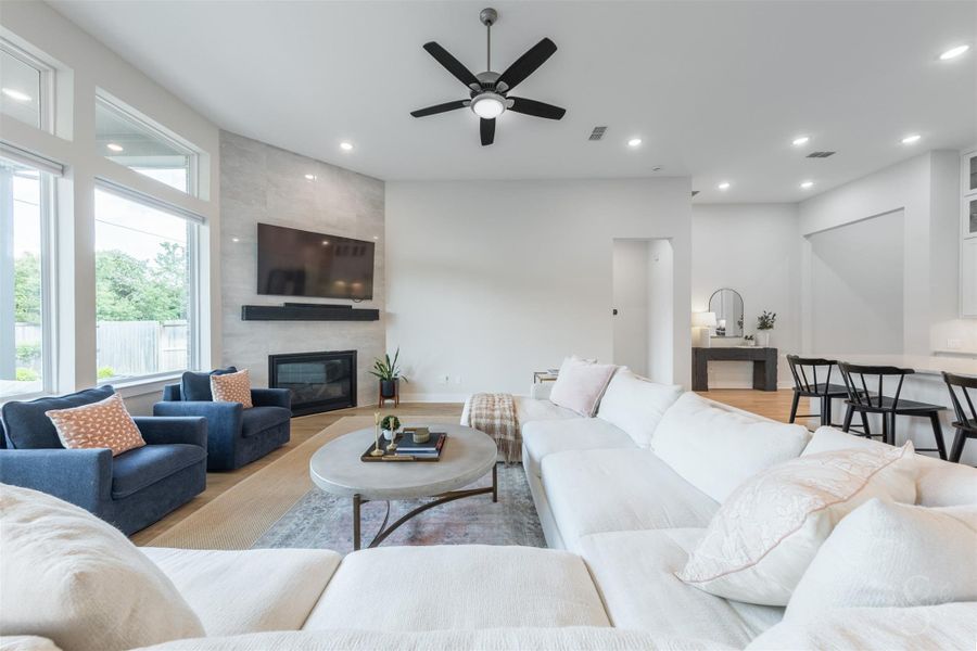 The floor-to-ceiling tiled fireplace creates a striking focal point in this beautifully appointed family room. Expansive windows and the open layout give the space a bright, airy feel. The floor-to-ceiling tiled fireplace creates a striking focal point in this beautifully appointed family room. Expansive windows and the open layout give the space a bright, airy feel.
