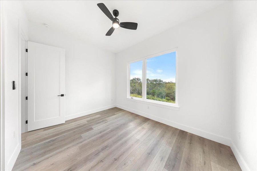 Unfurnished room featuring light wood-type flooring and ceiling fan Unfurnished room featuring light wood-type flooring and ceiling fan