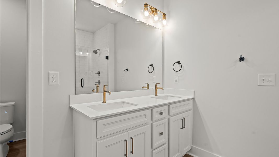 Superior en-suite primary bathroom with stylish dual vanity and tiled walk-in shower crafted with high standards in mind Superior en-suite primary bathroom with stylish dual vanity and tiled walk-in shower crafted with high standards in mind