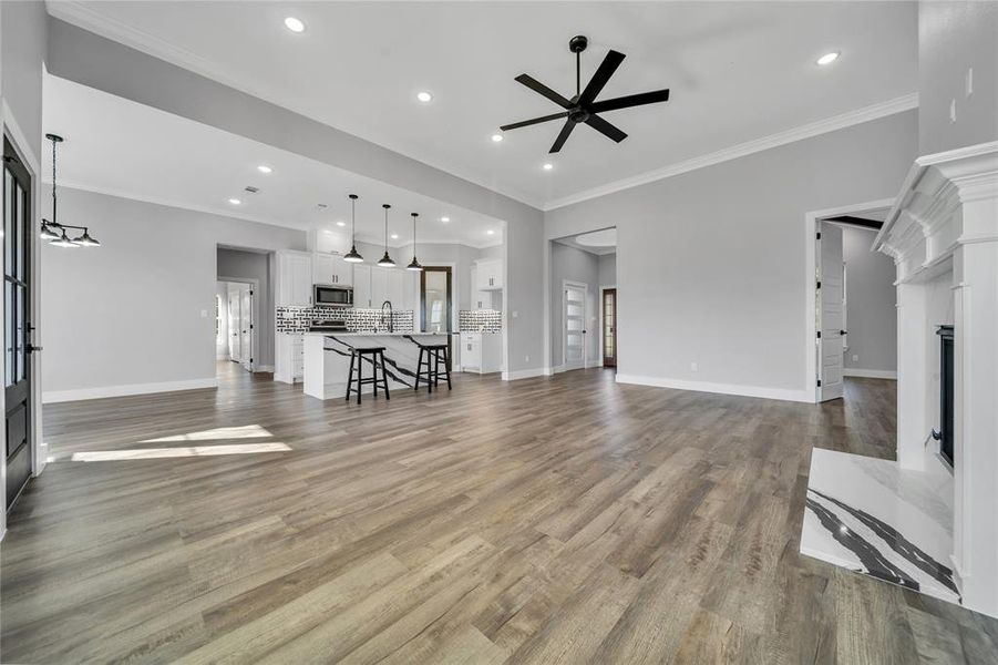 Living room featuring hardwood / wood-style floors, ceiling fan, and crown molding