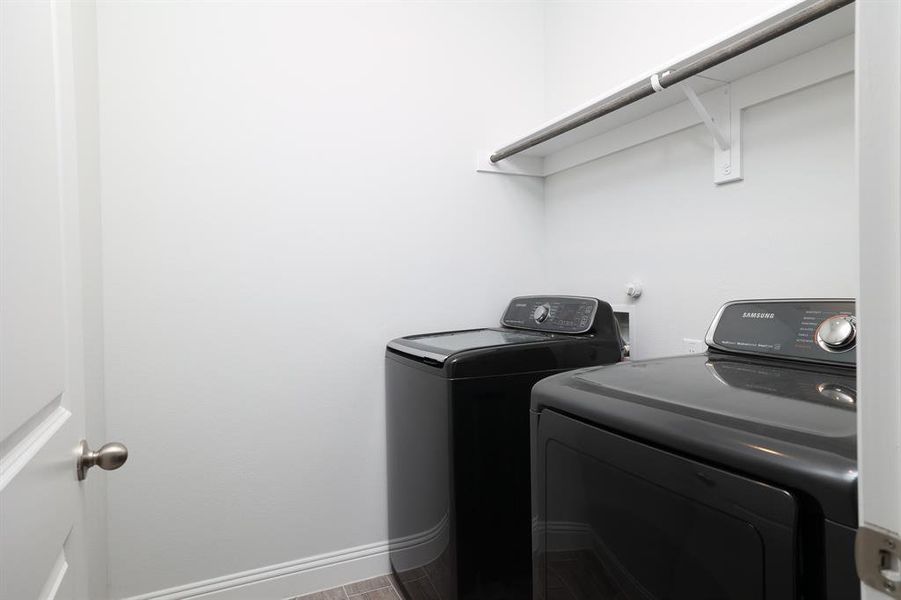Laundry room with washer and clothes dryer and baseboards