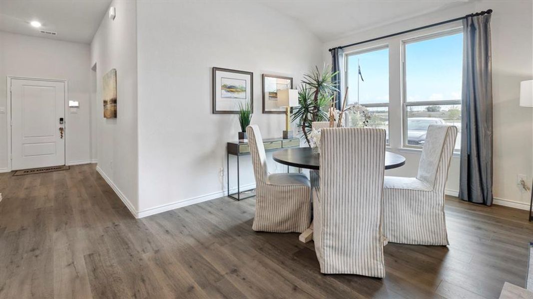 Dining space featuring vaulted ceiling and dark wood finished floors