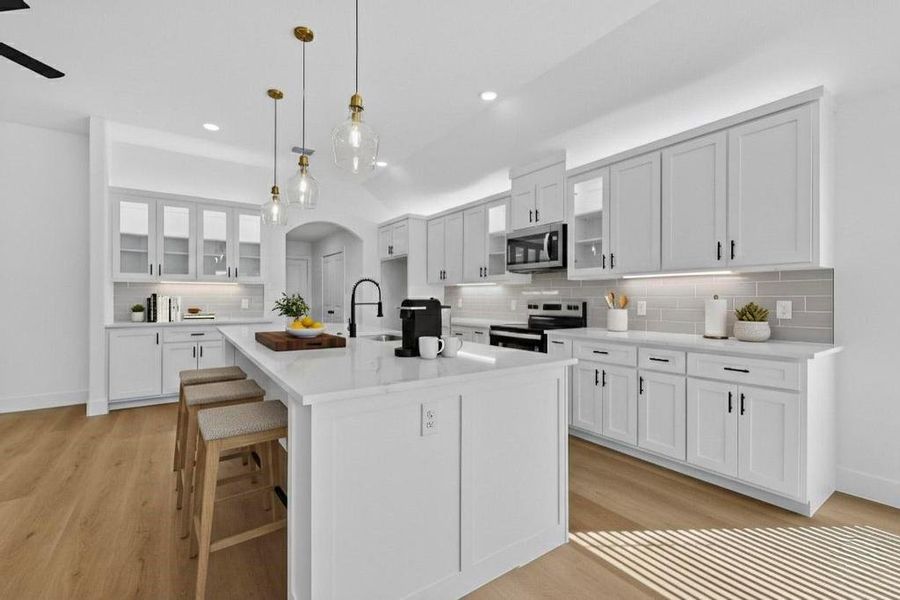 Kitchen with glass insert cabinets, arched walkways, a breakfast bar area, and white cabinets