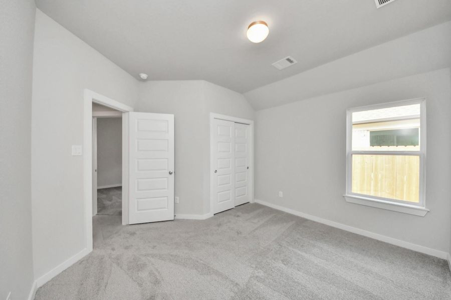 Generously sized secondary bedrooms featuring spacious closets, soft and inviting carpeting underfoot, large windows allowing plenty of natural light, and the added touch of privacy blinds for your personal retreat. Sample photo of completed home with similar floor plan. Actual colors and selections may vary.