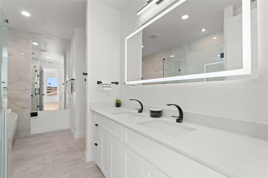 Full bath with double vanity, recessed lighting, and a shower with door