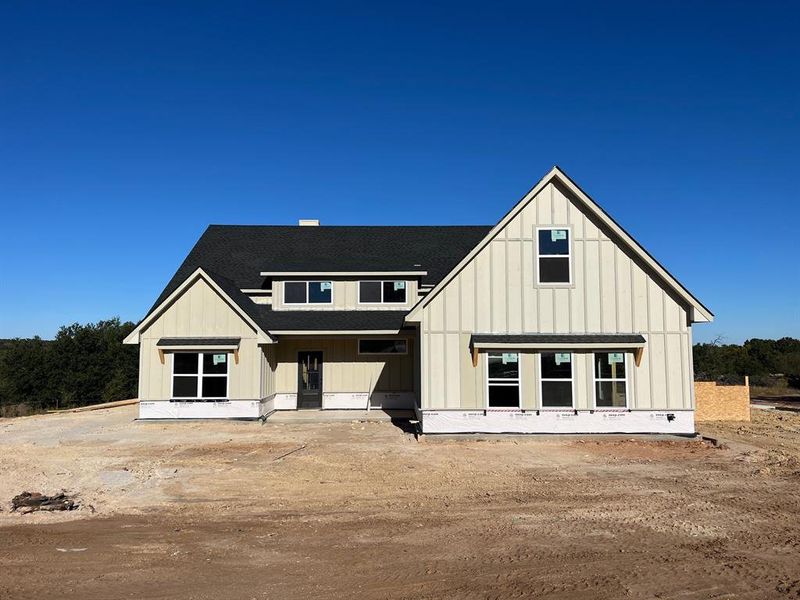 Modern inspired farmhouse featuring a shingled roof and board and batten siding