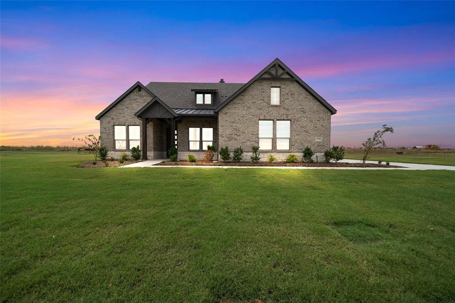 Modern farmhouse style home with brick siding, a standing seam roof, a metal roof, and a yard Modern farmhouse style home with brick siding, a standing seam roof, a metal roof, and a yard