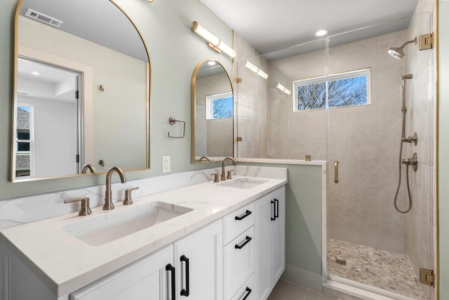 Attached primary bathroom features dual sinks and a walk-in shower.