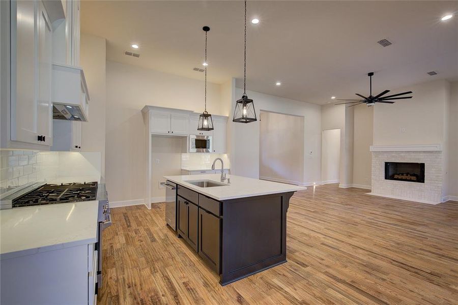 Island has undermount single sink and dishwasher, pendant lighting.