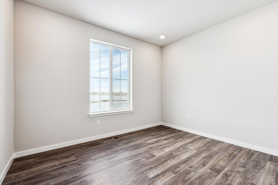 A room with a window and a wood floor.