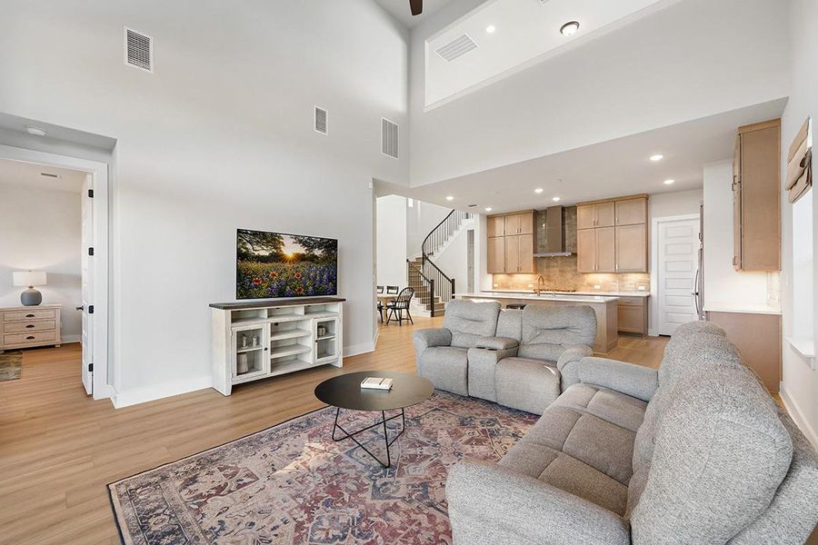 Soaring ceilings and warm wood floors anchor this expansive open-concept main level.
