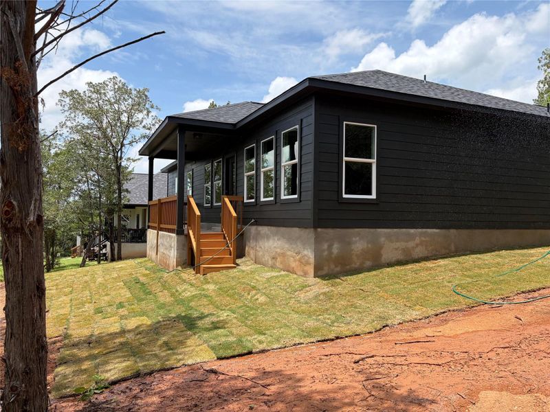 A newly sodded lawn accents the modern dark exterior and welcoming deck of this residence. A newly sodded lawn accents the modern dark exterior and welcoming deck of this residence.
