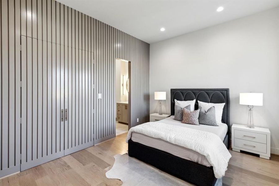 Bedroom with connected bathroom and light wood-type flooring