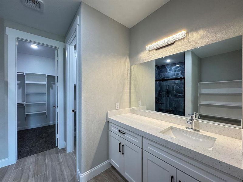 Bathroom vanity with a white composite countertop and integrated sink