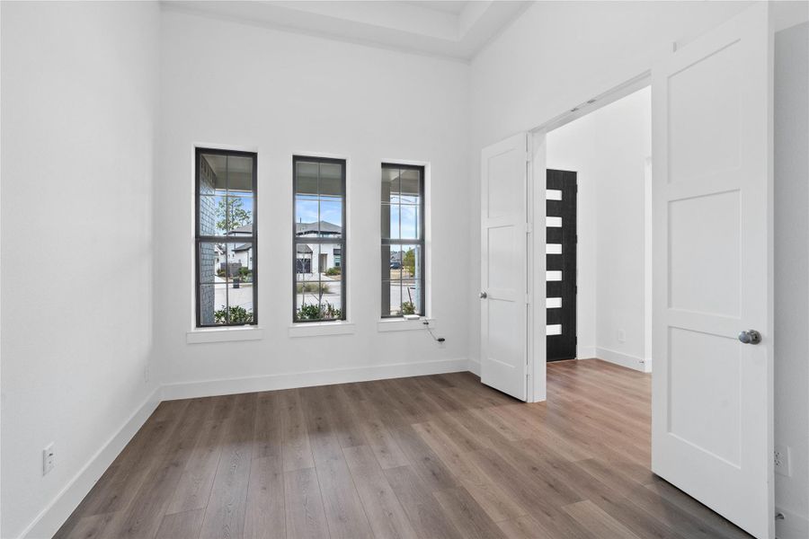 This handsome Study features laminate flooring, large windows, tray ceiling, lighting, custom paint, and double doors for privacy.