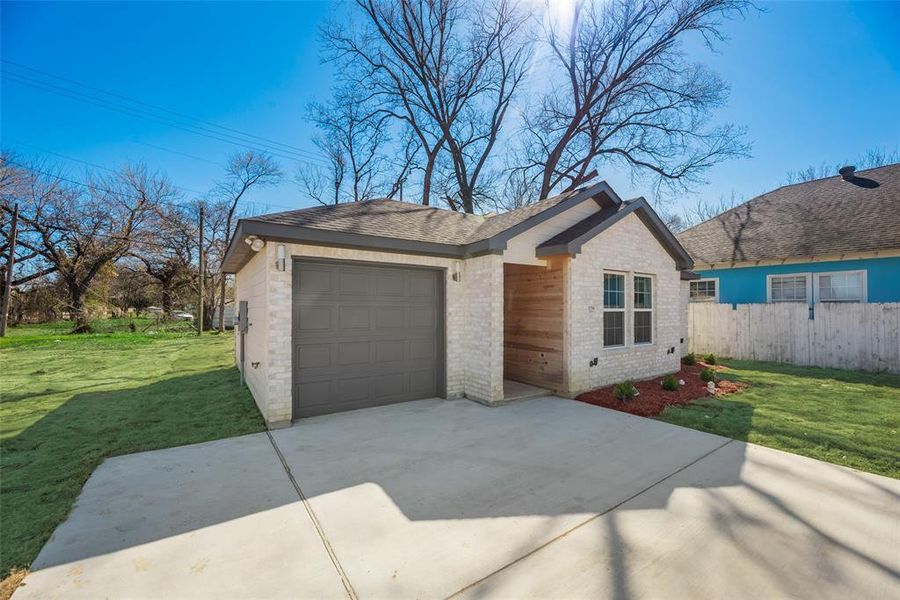 Ranch-style home featuring a garage and a front yard