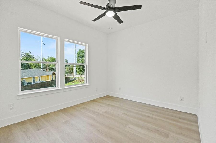 Empty room featuring light wood-type flooring and ceiling fan