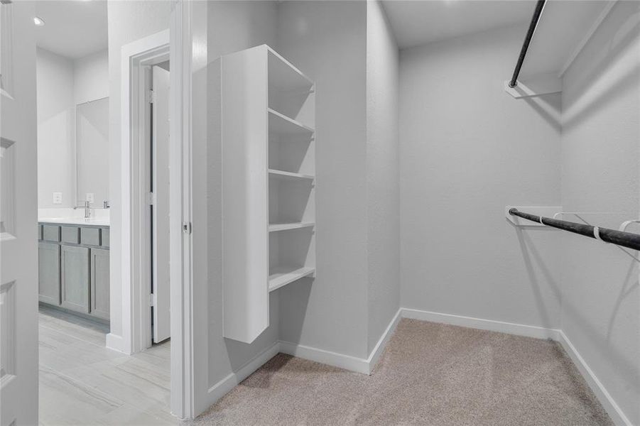 Step into luxury with this spacious walk-in closet, thoughtfully designed with ample shelving to keep your wardrobe beautifully organized. Featuring open shelving and hanging space, it provides the perfect blend of functionality and elegance.