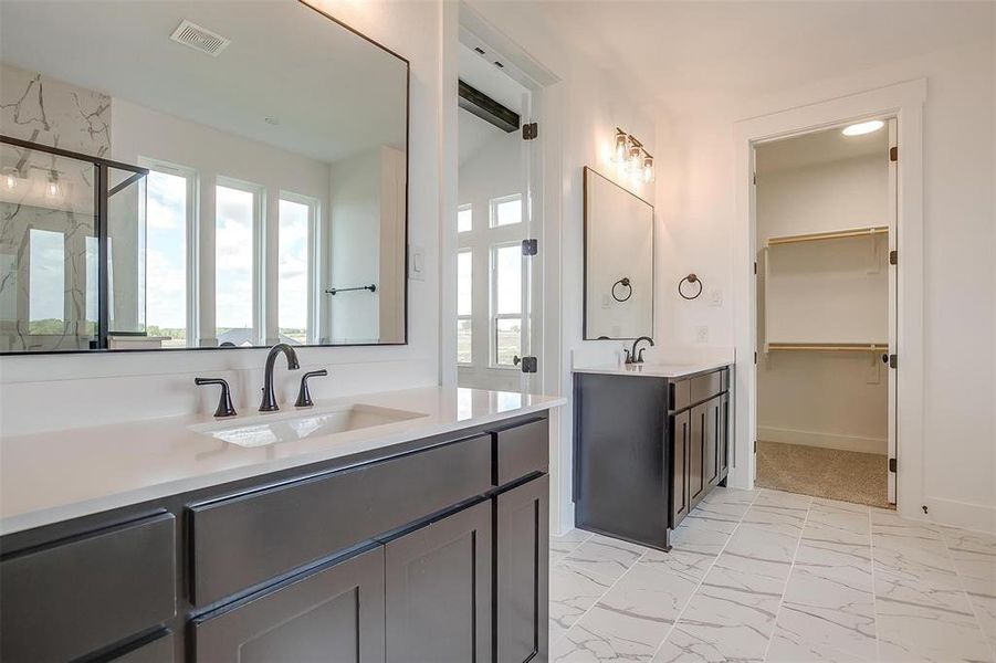 Bathroom featuring vanity and a shower with door