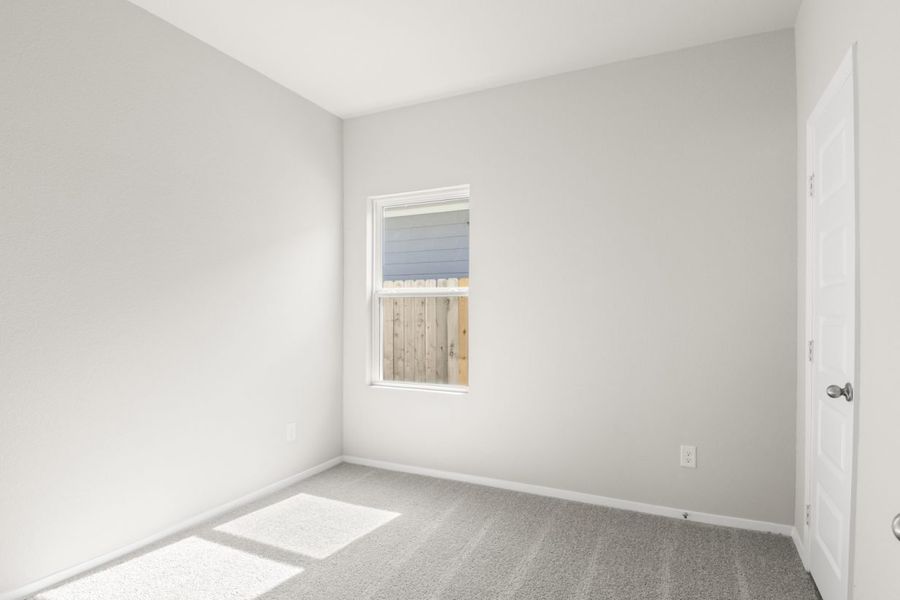 Image of a bedroom with light grey carpet and painted walls with a window Image of a bedroom with light grey carpet and painted walls with a window