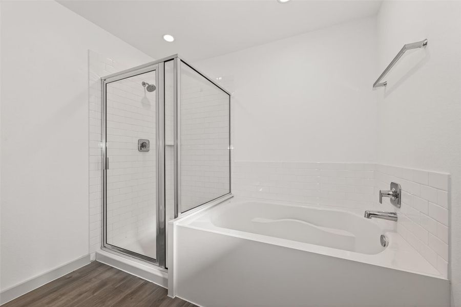 Separate soaking tub and shower detailed with white tiling. Separate soaking tub and shower detailed with white tiling.