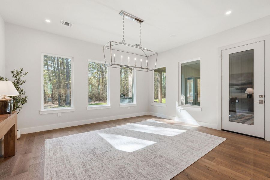 Anchored by a dramaticchandelier and surrounded bynatural light, this dining spaceconnects seamlessly to both thekitchen and living room. Glassdoors extend the space outdoorsto the covered back patio,creating an ideal setting forrelaxed meals and entertainingalike